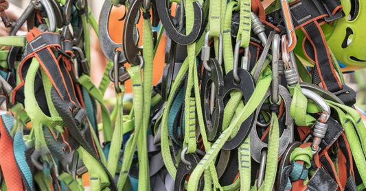 Close-up of several fall protection lanyards in various colors, like yellow and orange, hanging together from carabiners.
